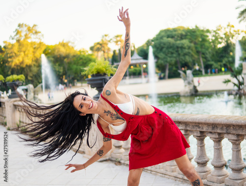 tattooed transgender model is dancing in the green park. Emotional dance movements