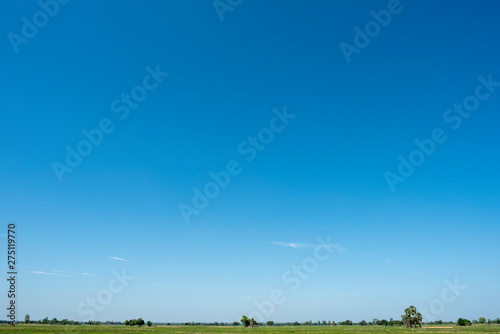 Blue sky background with green fields.