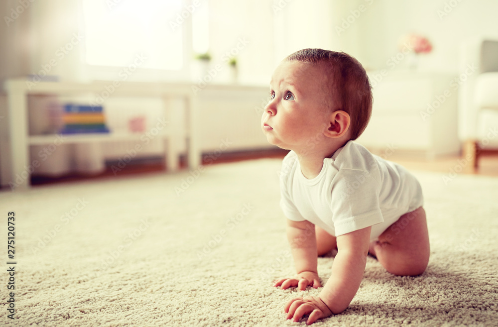 childhood, babyhood and people concept - little baby boy or girl crawling on floor at home childhood, babyhood and people concept - little baby boy or girl crawling on floor at home