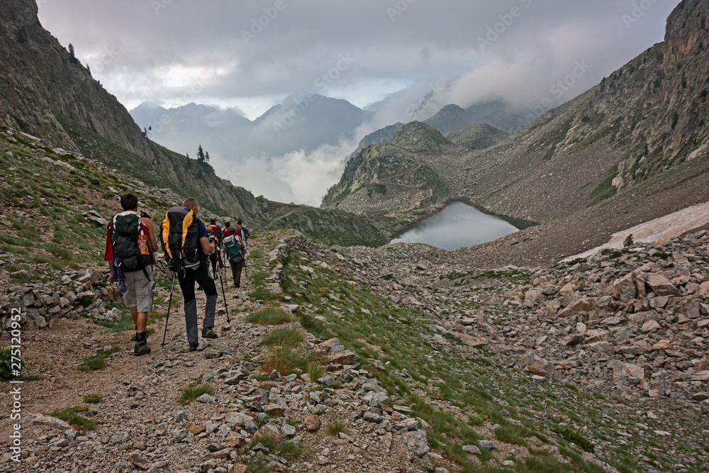 Hikers on a mountain trail in the Maritime Alps in the morning.
