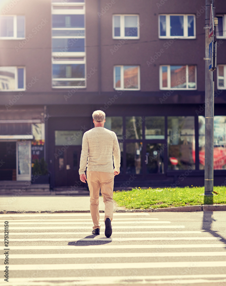 leisure and people concept - senior man walking along summer city crosswalk leisure and people concept - senior man walking along summer city crosswalk