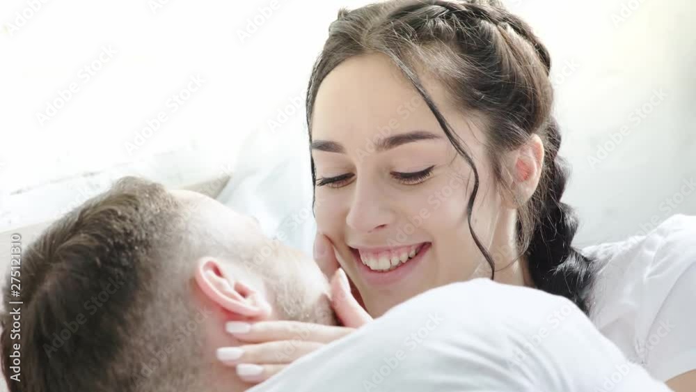 cheerful brunette woman looking at boyfriend and touching face at home cheerful brunette woman looking at boyfriend and touching face at home