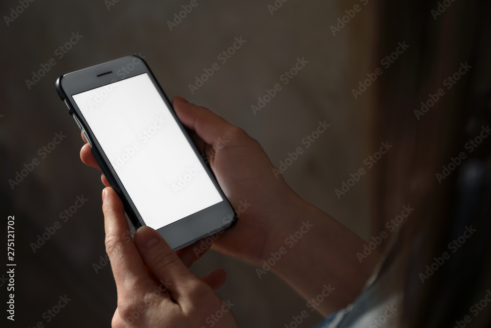 Woman using smartphone in dark room, closeup with space for text. Loneliness concept