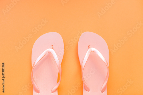 Living coral flip flops on a coral background. Color of the year 2019. Place for text.
