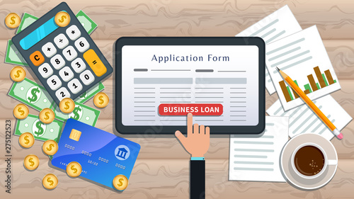 Online business loan or lending concept. Home mortgage. Flat tablet with loan application form and hand click button on desk with cash, calculator, credit card, pencil, cup of coffee, chart.