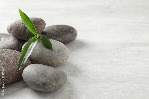 Spa stones with bamboo on grey background. Space for text