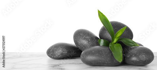 Black spa stones with bamboo on table against white background. Space for text