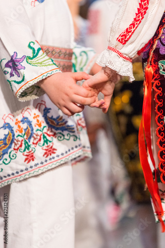 Close up of hands of young Romanian dancers perform a folk dance in traditional folkloric costume. Folklore of Romania