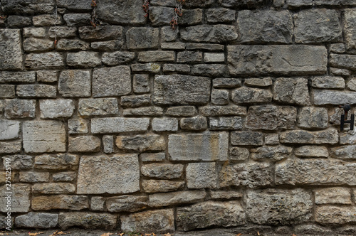 Alte Natursteinmauer aus grauen und gelblichen Steinen in unterschiedlichen Größen