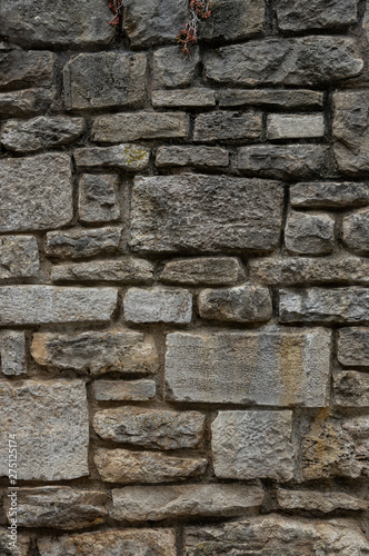 Alte Natursteinmauer aus grauen und gelblichen Steinen in unterschiedlichen Größen