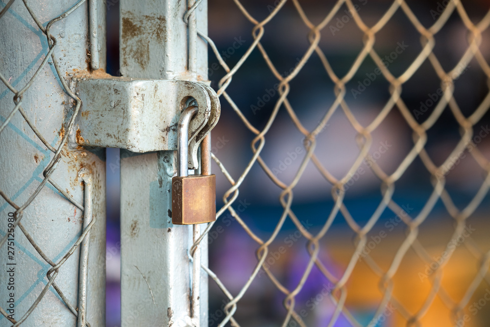 Key lock on wire grating storage door, using to secure the inventory in industrial warehouse. Object selected focus. Key lock on wire grating storage door, using to secure the inventory in industrial warehouse. Object selected focus.
