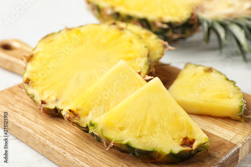 Cut fresh juicy pineapple on wooden board, closeup