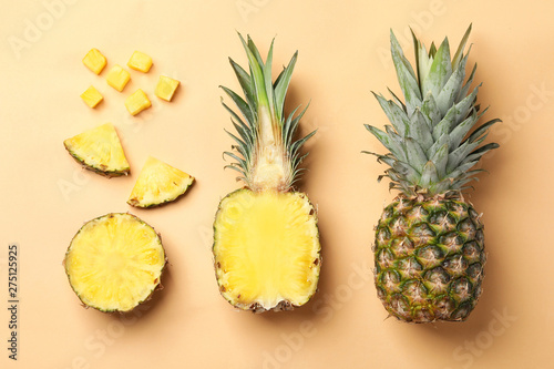 Flat lay composition with cut and fresh juicy pineapples on color background