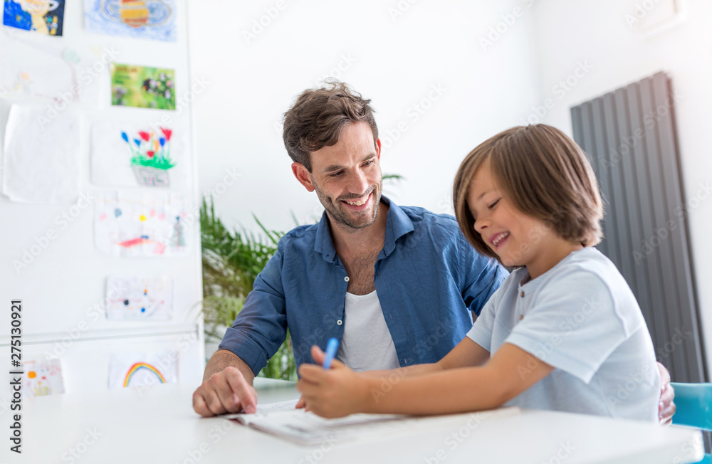 Father and son doing homework together at home Father and son doing homework together at home