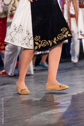 Close up of legs of young Romanian dancers perform a folk dance in traditional folkloric costume. Folklore of Romania