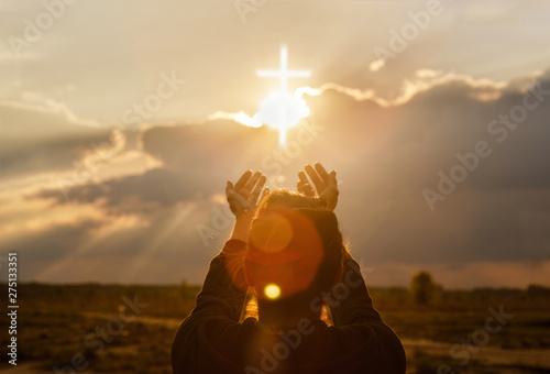 The woman extends her hand to the cross . Fototapet