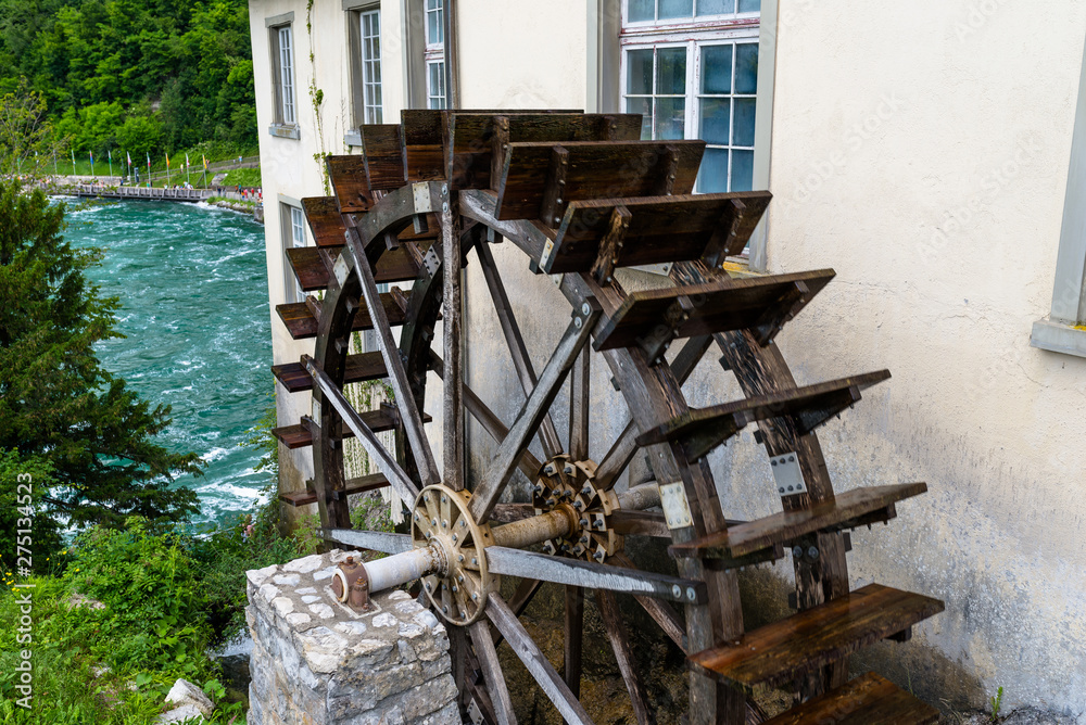 Working a wooden, water wheel  for converting the energy of flowing water, at the beginning of the Rhine river in Switzerland.