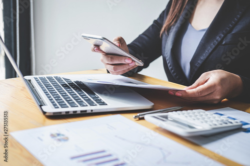 Businesswoman accountant working analyzing and calculating expense financial annual, financial balance sheet statement and analyze document graph and diagram, doing finance making notes on report