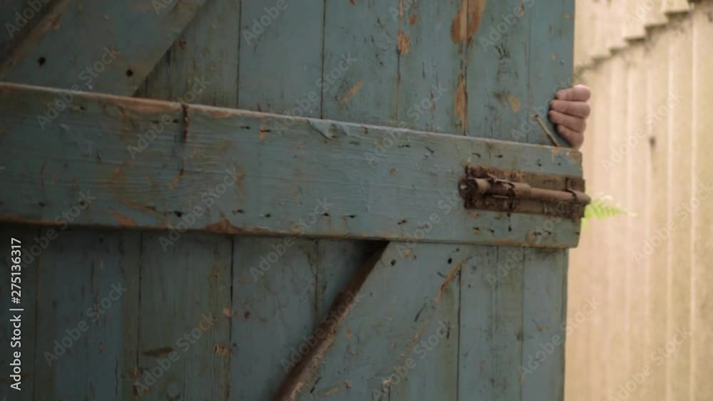 Hand opening an old wooden blue door to the outside, Hand opening an old wooden blue door to the outside,