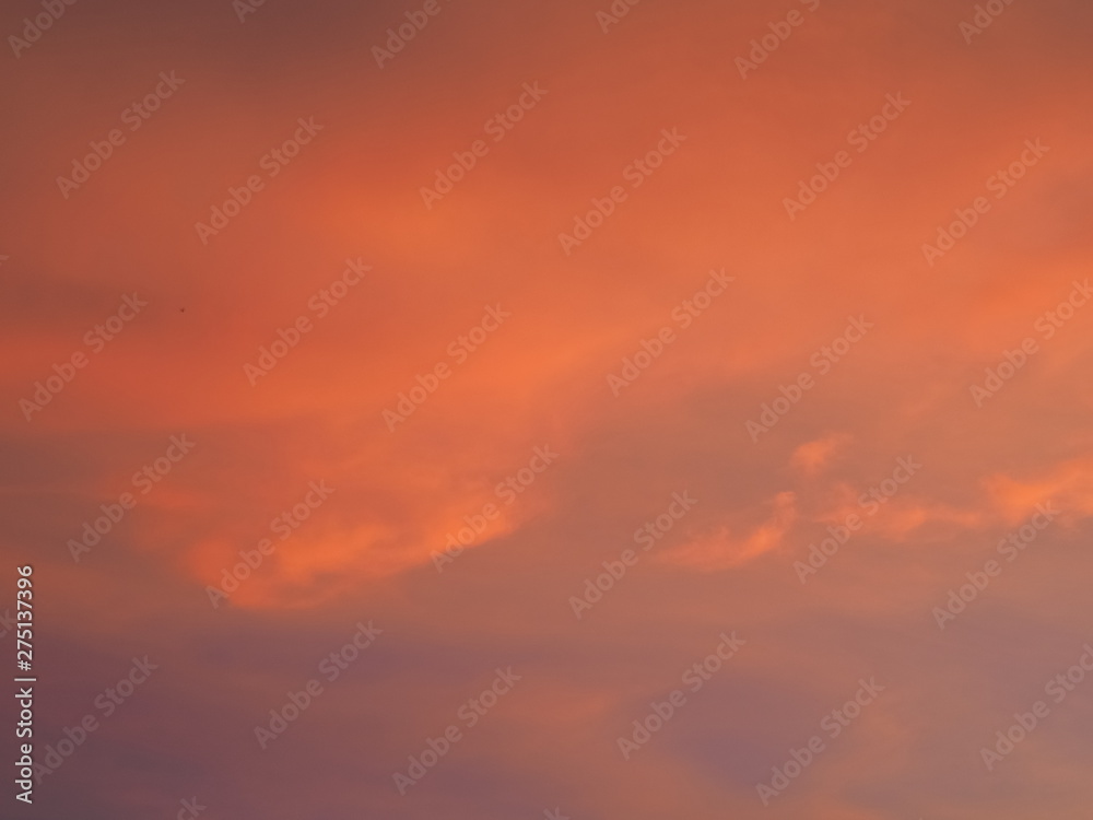 Twilight cloudy sky background, view of cloudy sky painted with red sun light after sunset.