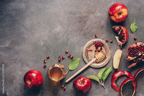 Apples, pomegranate and honey on a dark rustic background. Traditional Jewish food. New Year - Rosh Hashanah. Top view, copy space, flat lay. photo