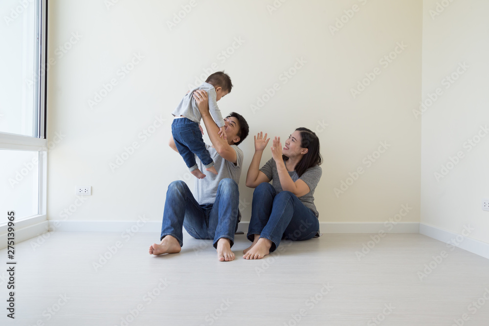 Happy Asian family with empty room in new house at moving day Happy Asian family with empty room in new house at moving day