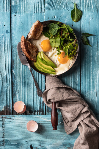 Fried eggs with green on a blue surface photo