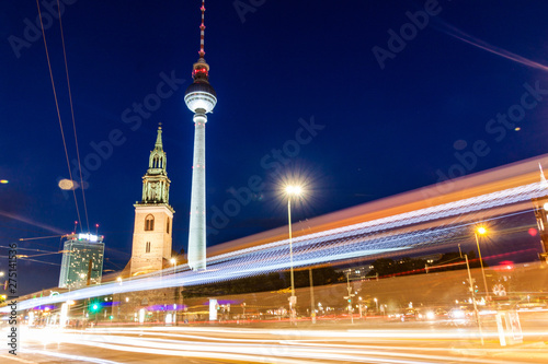 BERLIN, GERMANY - AUGUST 9, 2017: Evening view of Marienkirche (St. Mary's Church) and Fernsehturm (TV tower) with blured light of traffic.