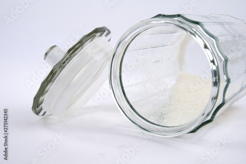 Sugar in glass transparent vase on white background photo