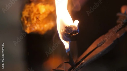 Riveting rose iron in flame kept at fire in a traditional blacksmith workshop  photo