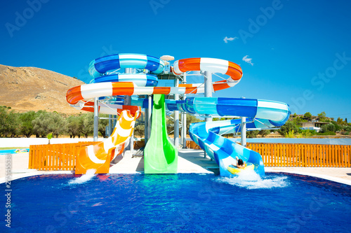 colorful open-air water slides with a rearward-facing child, front view photo