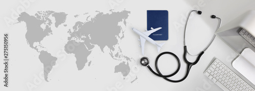 international medical travel insurance concept, stethoscope, passport, computer and airplane on desk office banner with global map