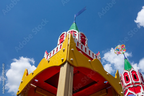 Castle tower tops of kids playground on a cloudy blue sky background. Closeup of children outdoor