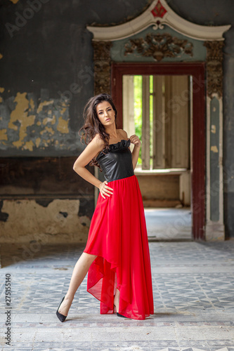 Young woman in red dress in old room
