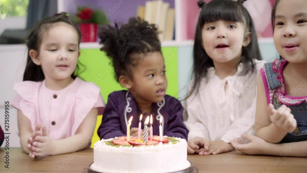 Group of children celebrate birthday's party in classroom, Multi-ethnic young boys and girls happy make a wish blow out candles on birthday cake at school. Kids celebrate birthday at school concept. Group of children celebrate birthday's party in classroom, Multi-ethnic young boys and girls happy make a wish blow out candles on birthday cake at school. Kids celebrate birthday at school concept.