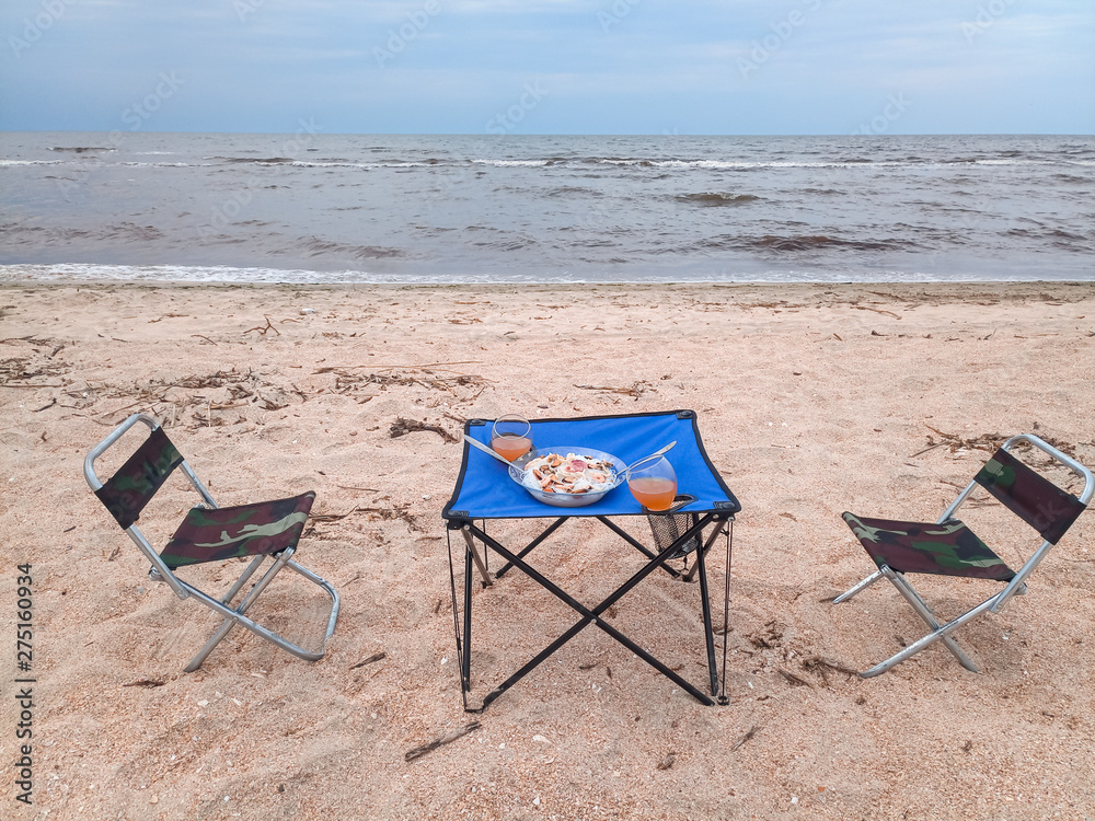 Lunch by the sea, tourist folding furniture, chairs and a table. Lunch by the sea, tourist folding furniture, chairs and a table.