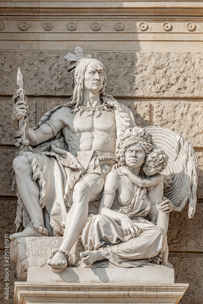 Old symbolic statue of indigenous people of America and Australia, Inca or Indian warier with spire and aborigine woman with a child located in museums district, downtown in Vienna, Austria