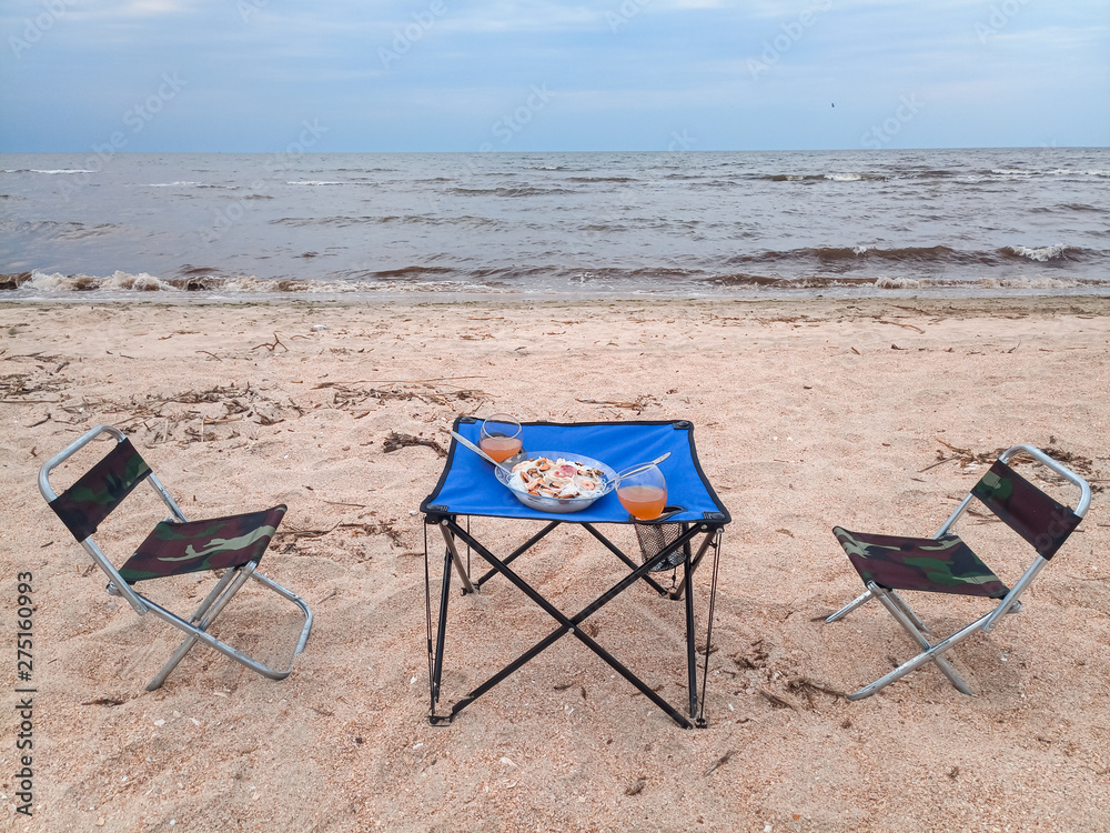 Lunch by the sea, tourist folding furniture, chairs and a table. Lunch by the sea, tourist folding furniture, chairs and a table.