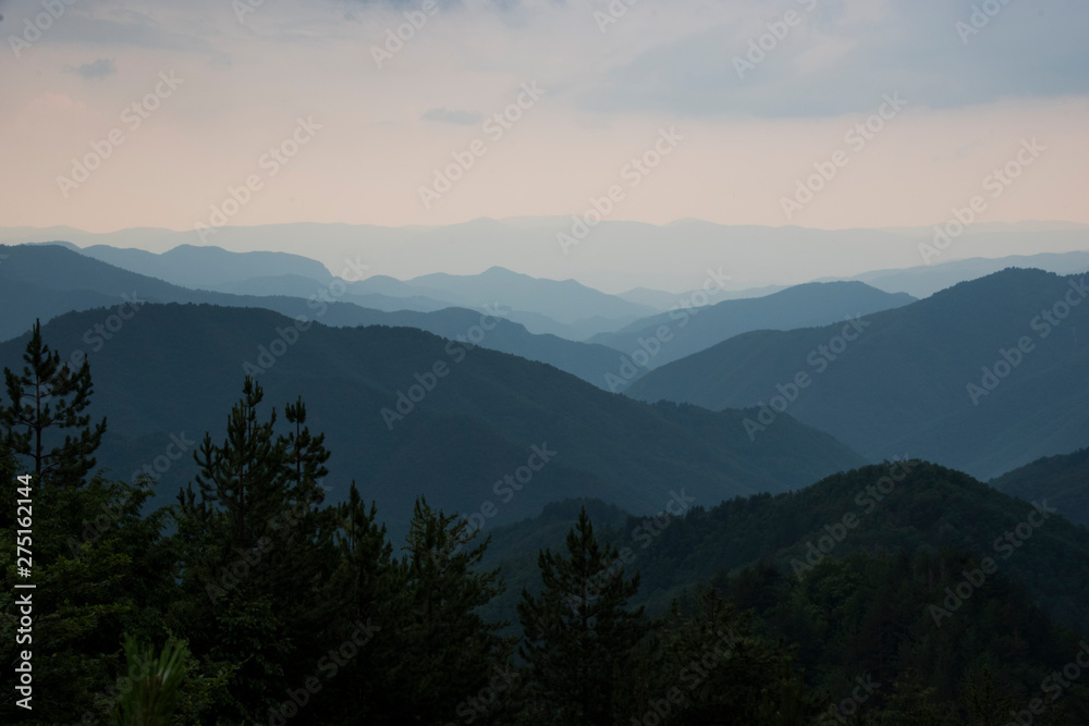 Panoramic landscape silhouettes of blue mountains with mist after rain in Rhodopi range