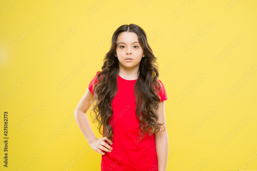 Kid cute face with adorable curly hairstyle. Little girl grow long hair.  Teen fashion model. Styling