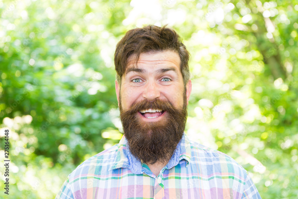 Fototapeta premium Hike and travel. Summer vacation concept. Man bearded hipster green trees background. Guy relax in summer nature. United with environment. Handsome lumberjack. Man beard and mustache in summer forest