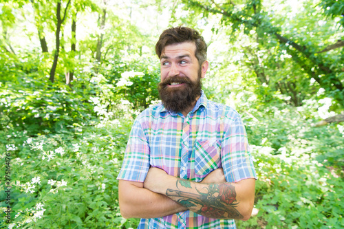 Guy relax in summer nature. Man handsome beard and mustache in summer forest. Summer vacation concept. United with environment. Man bearded hipster green trees background. Emotional nature lover