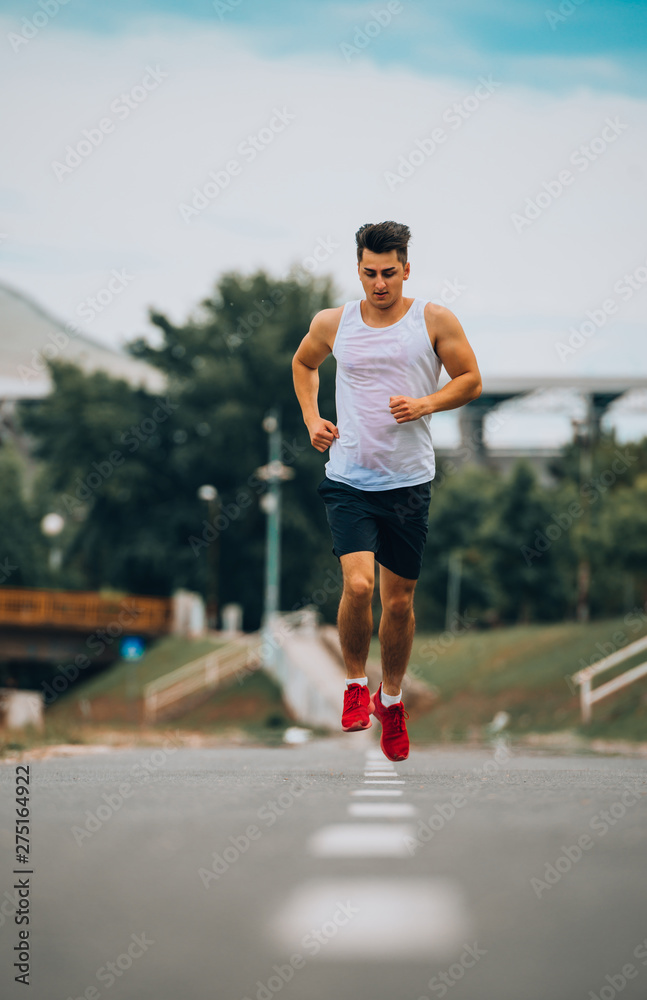 Young Caucaisan man running outdoors in park
