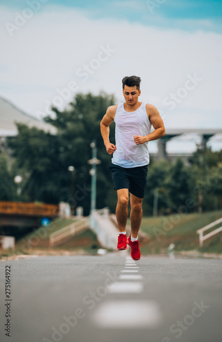 Young Caucaisan man running outdoors in park