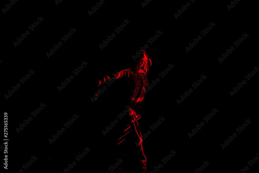 Ballet dancer dancing in front of and red light while expressing the hell with her magnificent dance moves. Ballet dancer dancing in front of and red light while expressing the hell with her magnificent dance moves.