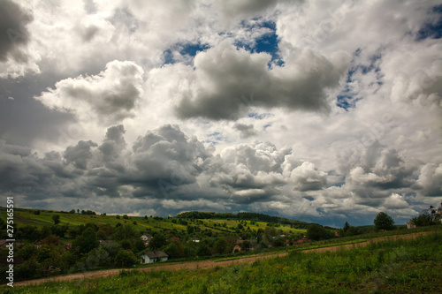 Rural landscape green fields on hills on the sky with clouds