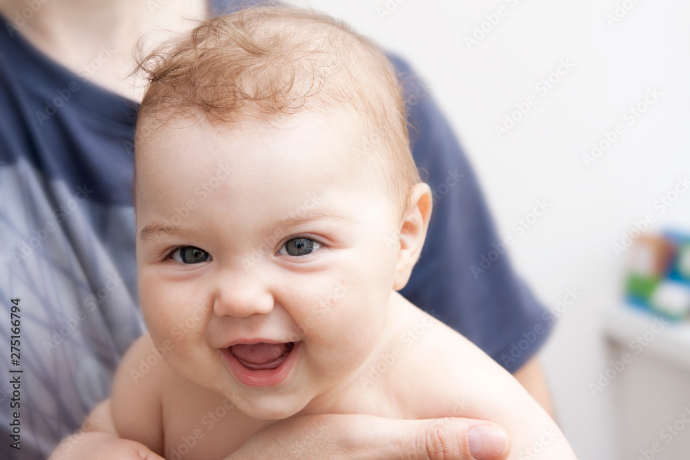 Healthy cheerful little baby smiling in his father's arms Healthy cheerful little baby smiling in his father's arms