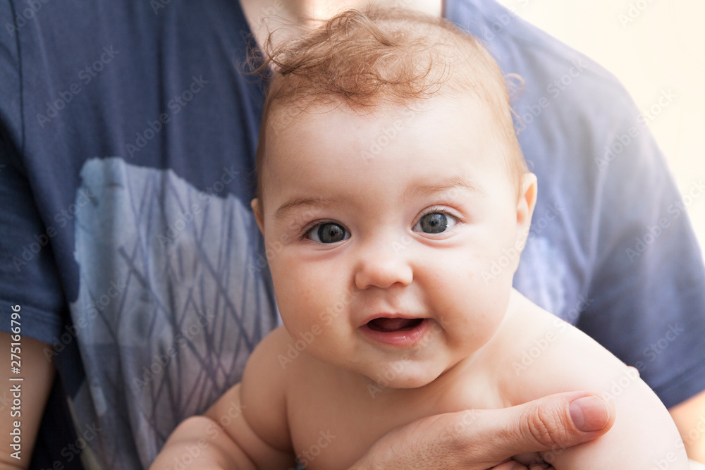 The child smiles at the hands of his father The child smiles at the hands of his father