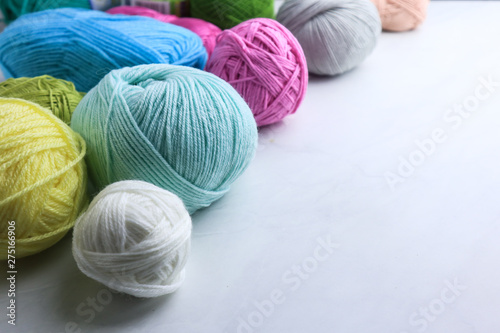 Colorful yarn balls on light grey background