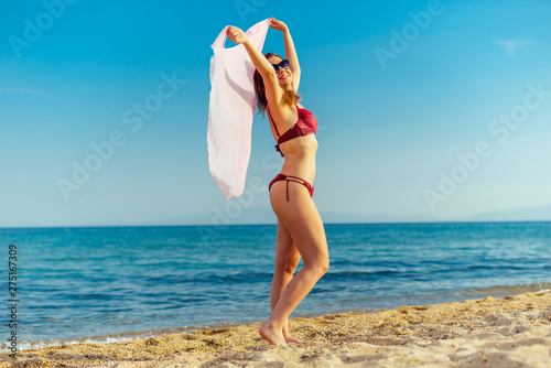Travel woman on beach enjoying blue sea and sky wearing sweamwear photo